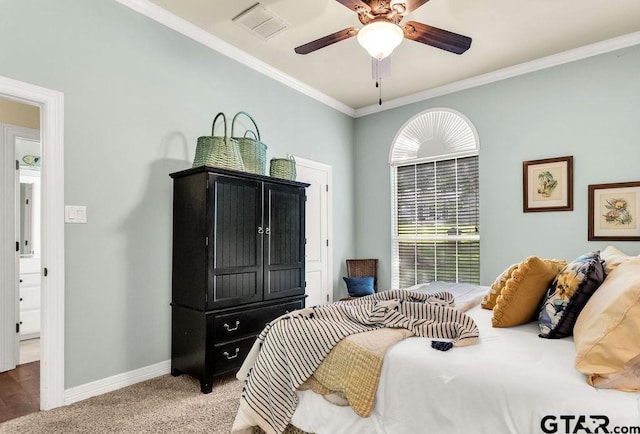 carpeted bedroom with visible vents, ornamental molding, baseboards, and ceiling fan