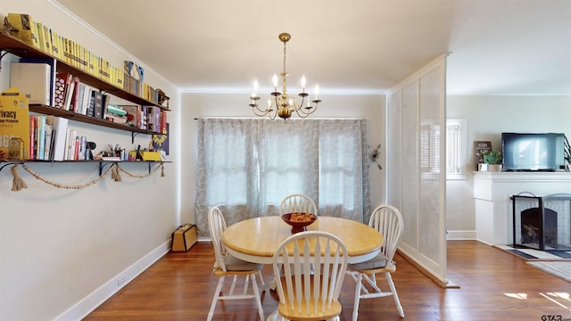 601 Troup Hwy, Tyler, TX 75701 - dining space featuring a chandelier, wood finished floors, crown molding, baseboards, and a fireplace