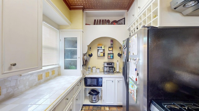 601 Troup Hwy, Tyler, TX 75701 - kitchen featuring stainless steel refrigerator with ice dispenser, tile countertops, white cabinets, black microwave, and plenty of natural light