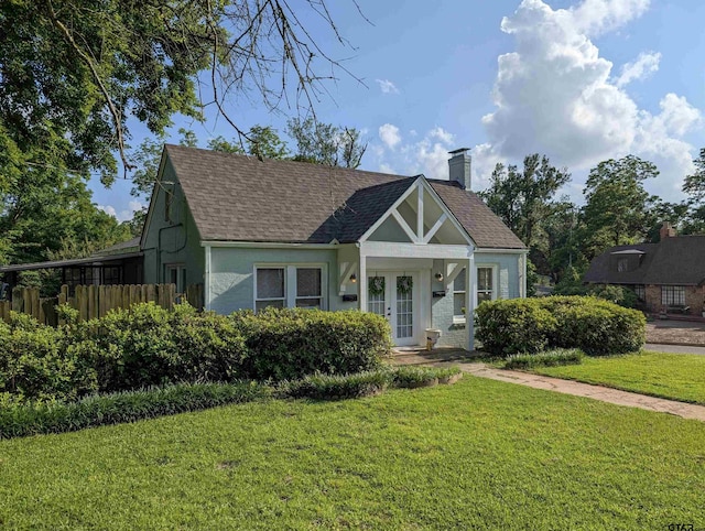 601 Troup Hwy, Tyler, TX 75701 - tudor-style house featuring a front lawn, french doors, roof with shingles, and a chimney
