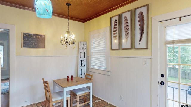 601 Troup Hwy, Tyler, TX 75701 - dining area with a wainscoted wall, ornamental molding, a chandelier, and brick patterned floors