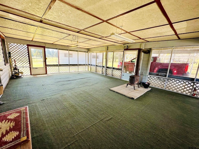 unfurnished sunroom with a wood stove