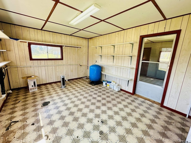 workout room with tile patterned floors, wooden walls, and baseboards