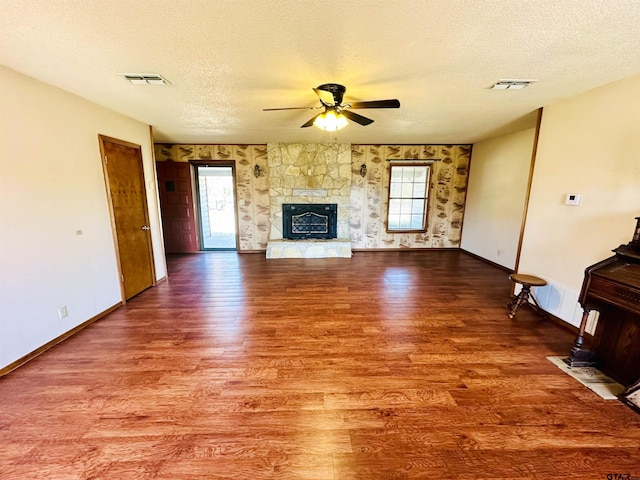 unfurnished living room with a wealth of natural light, visible vents, and wood finished floors