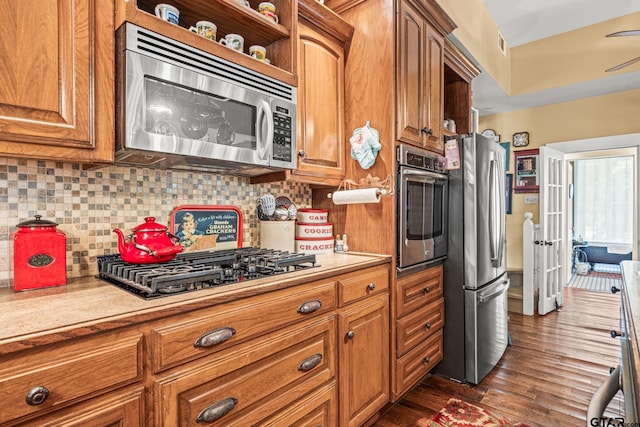 kitchen featuring stainless steel appliances, dark wood-type flooring, and decorative backsplash