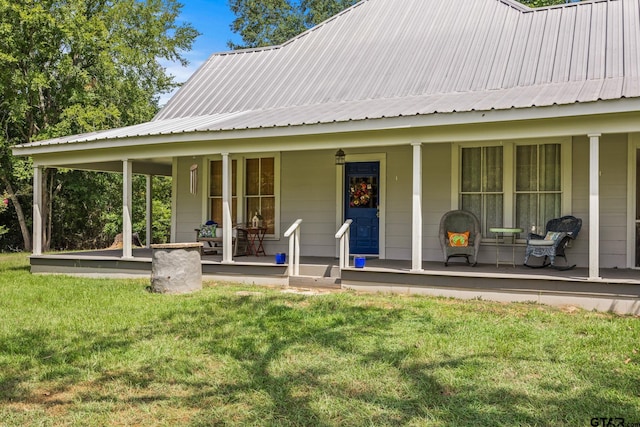 back of house with a lawn and covered porch