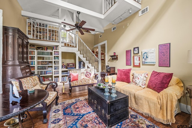 living room with high vaulted ceiling, hardwood / wood-style flooring, ceiling fan, and beam ceiling