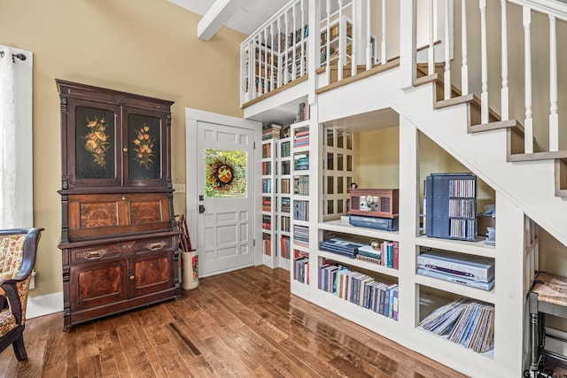 misc room with a towering ceiling and dark wood-type flooring