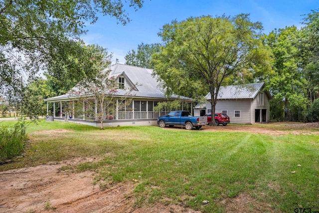 back of property with a sunroom and a yard