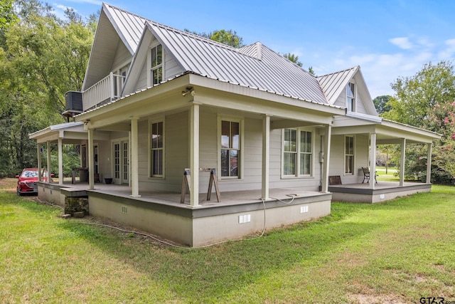 rear view of house featuring a porch and a yard