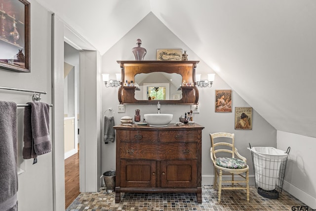 bathroom featuring vanity, hardwood / wood-style flooring, and vaulted ceiling