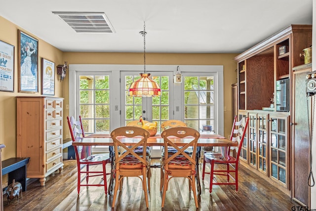 dining room featuring dark hardwood / wood-style floors, a healthy amount of sunlight, and french doors