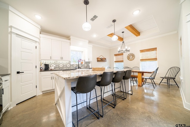 kitchen featuring pendant lighting, concrete floors, white cabinetry, and a kitchen island