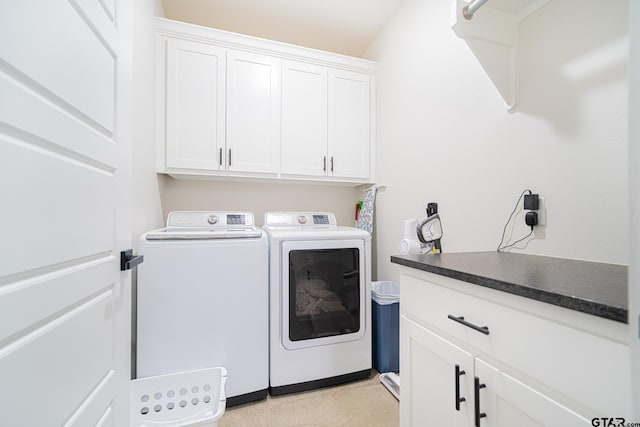 clothes washing area with cabinets and washer and clothes dryer