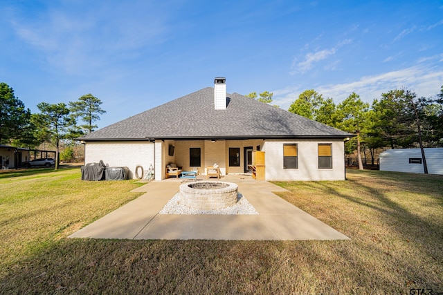 rear view of house with a patio, an outdoor fire pit, and a lawn