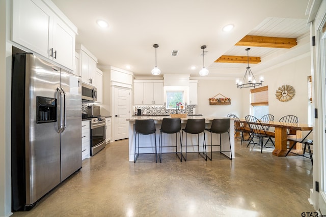 kitchen with hanging light fixtures, a kitchen island, beam ceiling, white cabinetry, and stainless steel appliances