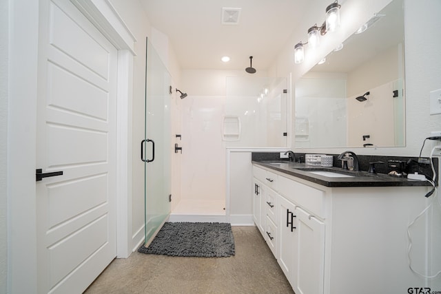 bathroom with vanity and a shower with shower door