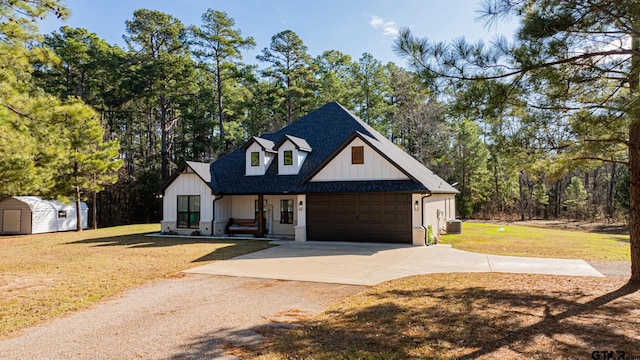 modern farmhouse with a garage, central AC unit, a front yard, and a storage shed