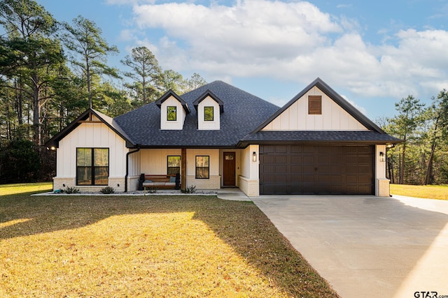 modern farmhouse with a garage, covered porch, and a front lawn