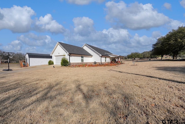 view of property exterior featuring board and batten siding, a lawn, and an attached garage