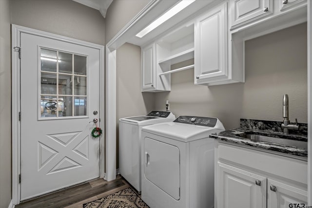 washroom with cabinets, separate washer and dryer, dark hardwood / wood-style floors, and sink