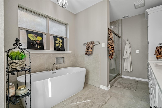 bathroom with tile patterned floors, vanity, independent shower and bath, and tile walls