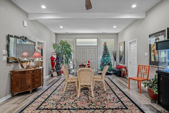 dining room featuring ceiling fan, beam ceiling, and light hardwood / wood-style flooring