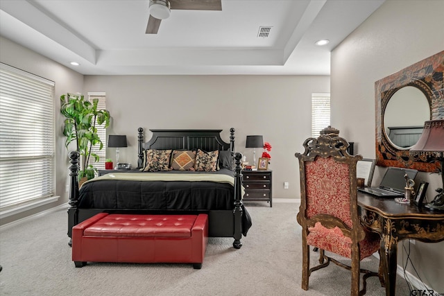 bedroom featuring a raised ceiling, ceiling fan, and carpet flooring