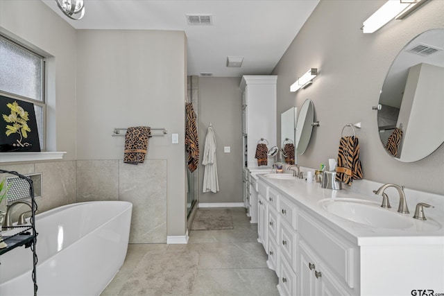 bathroom with tile patterned flooring, vanity, and a bathing tub