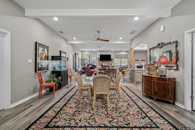 dining space with beam ceiling, light hardwood / wood-style flooring, and ceiling fan