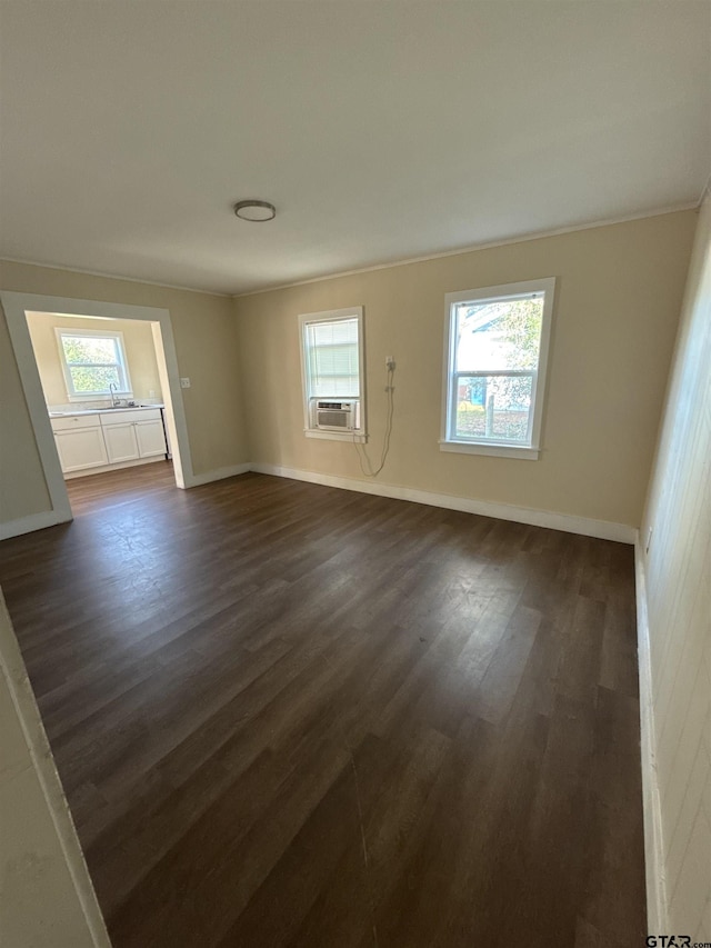 empty room featuring ornamental molding, dark wood-type flooring, and cooling unit