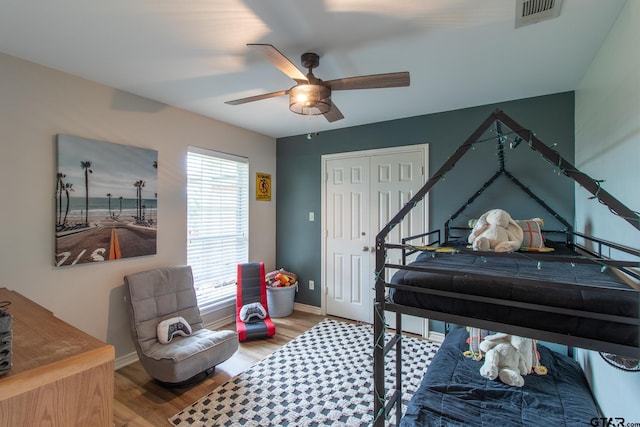 bedroom featuring hardwood / wood-style floors, ceiling fan, and a closet