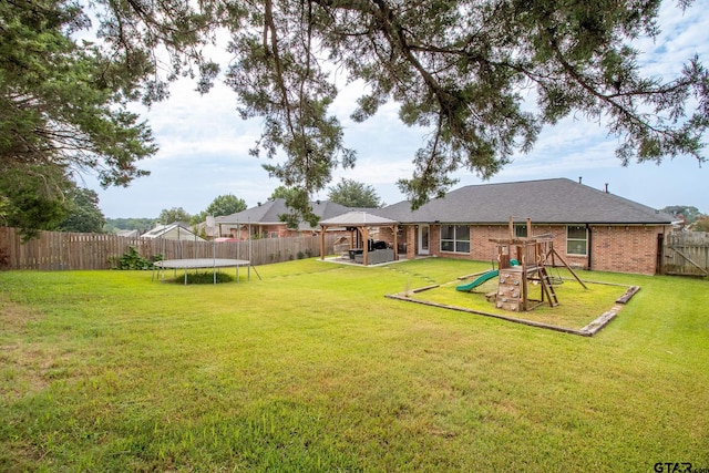 view of yard featuring a trampoline, a gazebo, and a playground