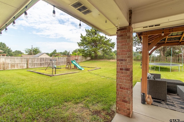 view of yard with a patio, a playground, and a trampoline