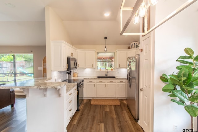 kitchen featuring white cabinetry, black appliances, kitchen peninsula, and a kitchen bar