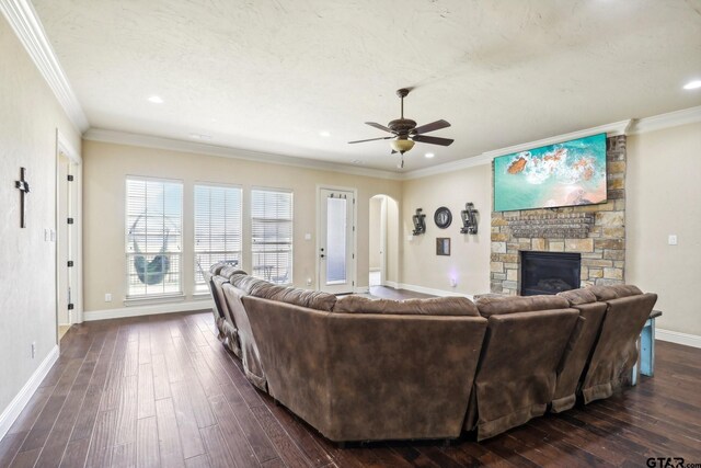 3449 Abes Landing Dr, Granbury, TX 76049 - living area featuring a ceiling fan, dark wood finished floors, a fireplace, arched walkways, and crown molding