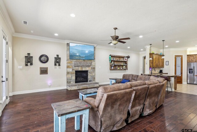 3449 Abes Landing Dr, Granbury, TX 76049 - living area with hardwood / wood-style flooring, a ceiling fan, recessed lighting, a stone fireplace, and crown molding