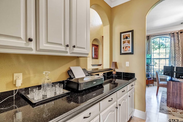 kitchen with dark stone countertops and white cabinets