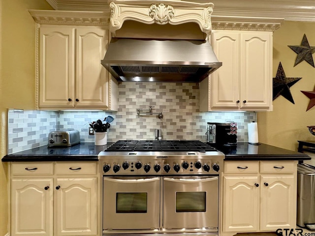 kitchen featuring white cabinetry, island range hood, ornamental molding, range with two ovens, and backsplash