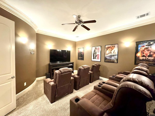 home theater room with crown molding, light colored carpet, and ceiling fan