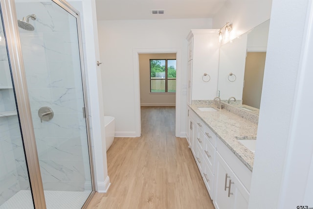 bathroom with separate shower and tub, hardwood / wood-style floors, and vanity