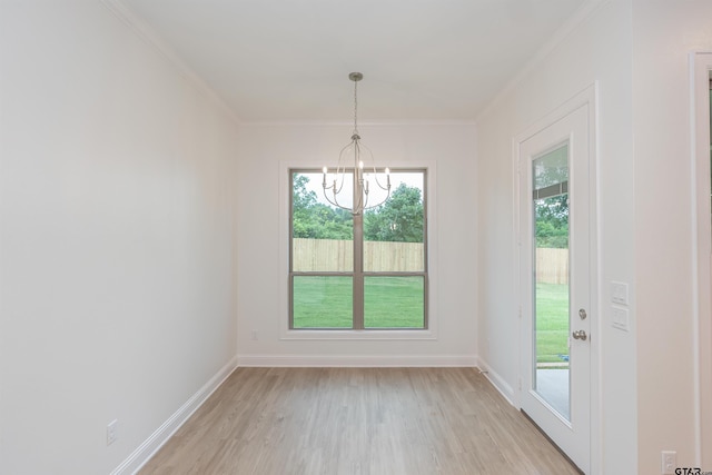 unfurnished dining area with a chandelier, crown molding, and light hardwood / wood-style flooring