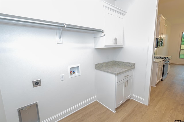 laundry area with cabinets, washer hookup, light hardwood / wood-style flooring, and electric dryer hookup