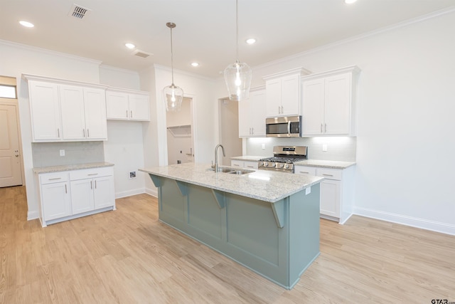 kitchen with light stone counters, white cabinetry, stainless steel appliances, and decorative light fixtures