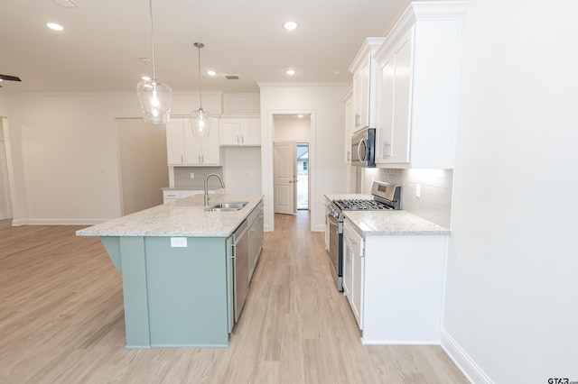 kitchen featuring white cabinetry, sink, hanging light fixtures, a center island with sink, and appliances with stainless steel finishes