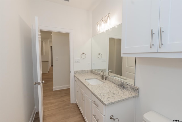 bathroom with hardwood / wood-style floors, vanity, and toilet