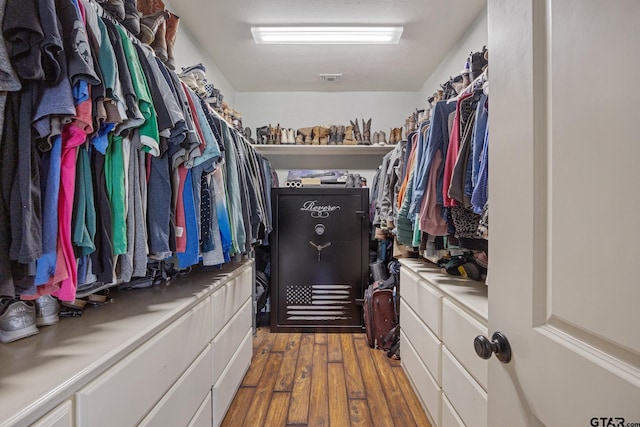 walk in closet with dark wood-type flooring