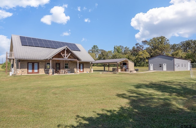 view of front of property featuring a front lawn, solar panels, and a carport