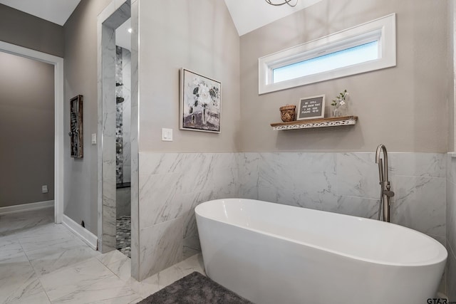 bathroom featuring independent shower and bath, lofted ceiling, and tile walls