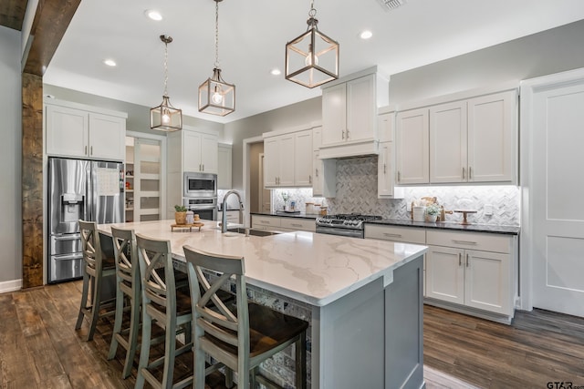 kitchen featuring dark wood-type flooring, pendant lighting, sink, white cabinetry, and appliances with stainless steel finishes